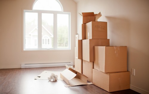 Professional movers carrying furniture through a narrow West London staircase
